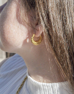 woman wearing 18 karat gold plated twisted shape hoop earrings