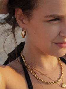woman wearing 18 karat gold plated hoop earrings and necklaces