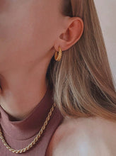 Load image into Gallery viewer, woman wearing 18 karat gold plated twisted shape hoop earrings and rope chain
