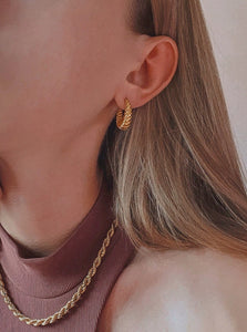 woman wearing 18 karat gold plated twisted shape hoop earrings and rope chain