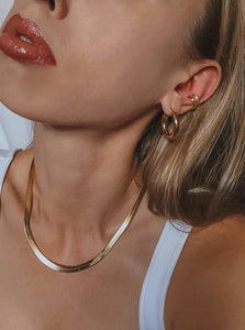 woman wearing 18 karat gold plated herringbone chain and hoop earrings  