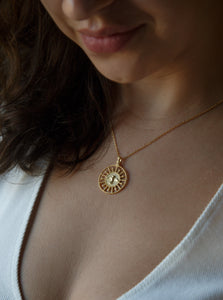 woman wearing 18 karat gold plated silver round necklace with a bird in the middle