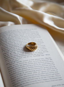 18 karat gold plate chunky statement ring laying on a book