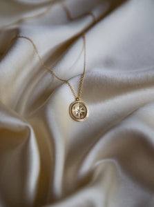 18 karat gold plated silver pendant necklace of a round shape with a cubic zirconia stone in the middle