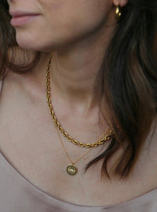 woman wearing 18 karat gold plated round pendant necklace and a rope chain
